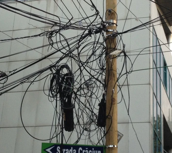 a telephone pole with lots of electrical wires hanging over it