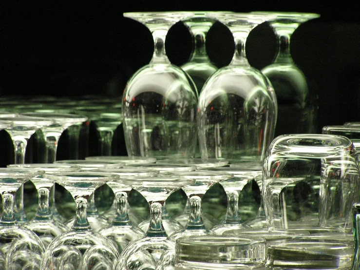 many wine glasses sitting around by a table