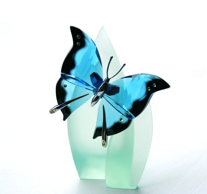 blue and black erfly sitting on glass vase