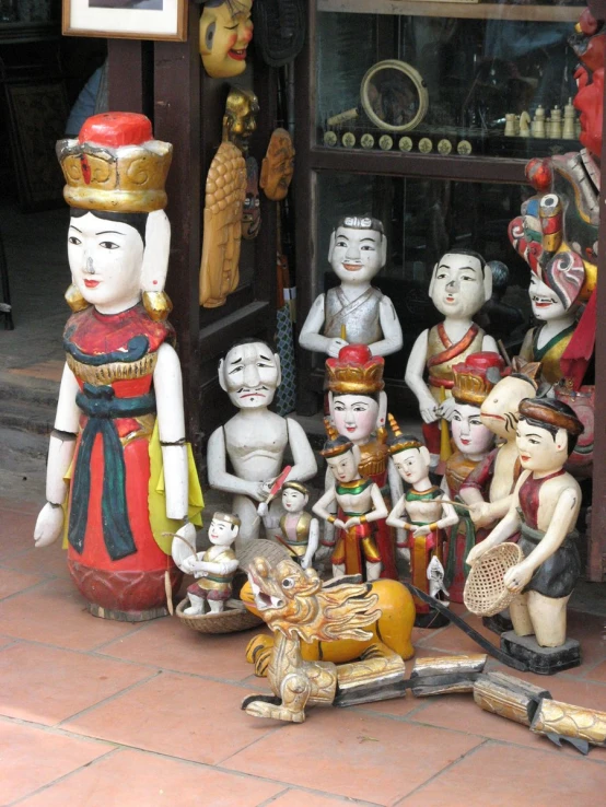 a statue on a display case is filled with small figurines