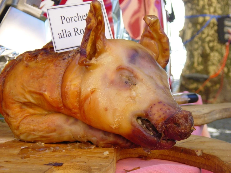 a cooked chicken sits on a wood  board