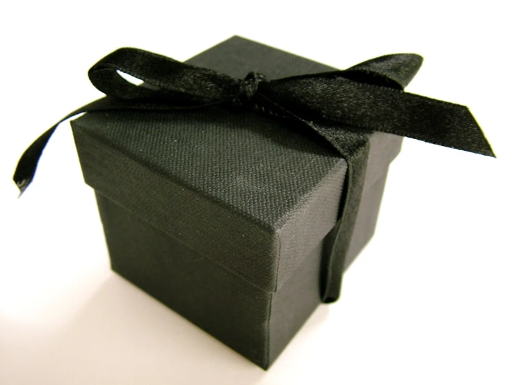a square, black box with a ribbon tied around the top