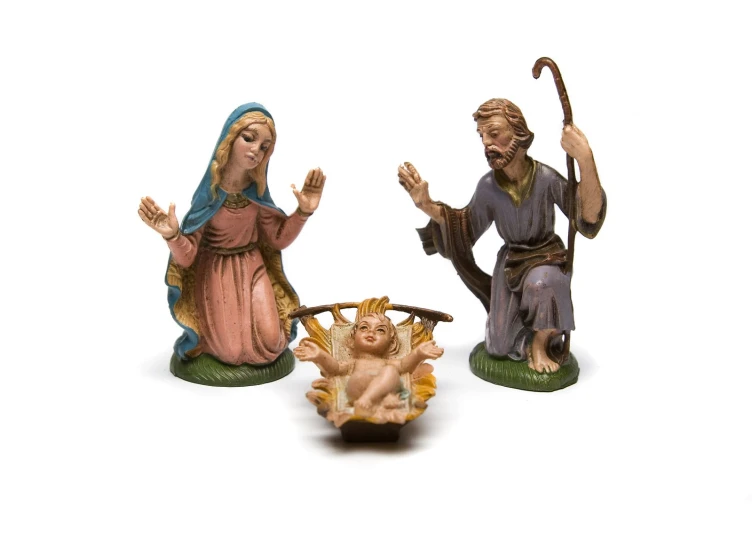 three religious figurines, one holding an umbrella, one sitting on a stool