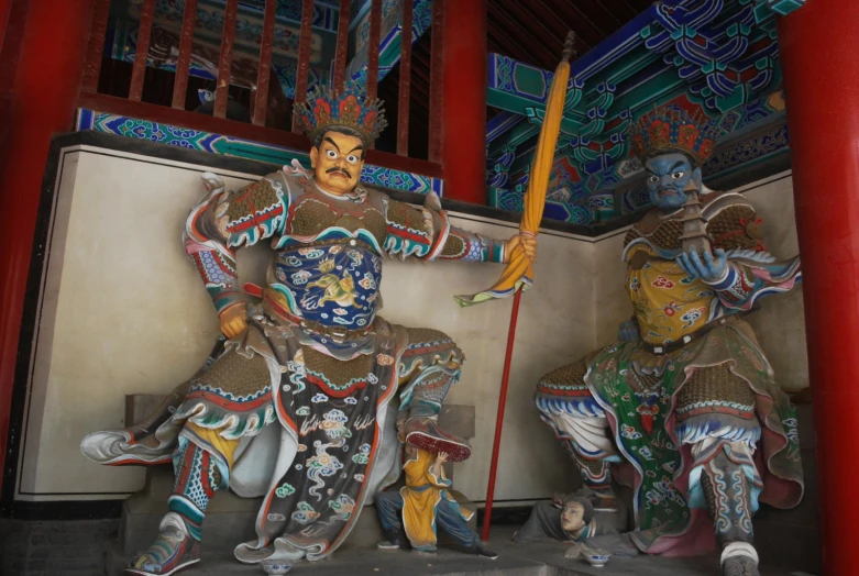 statues sitting on a wall in a chinese temple