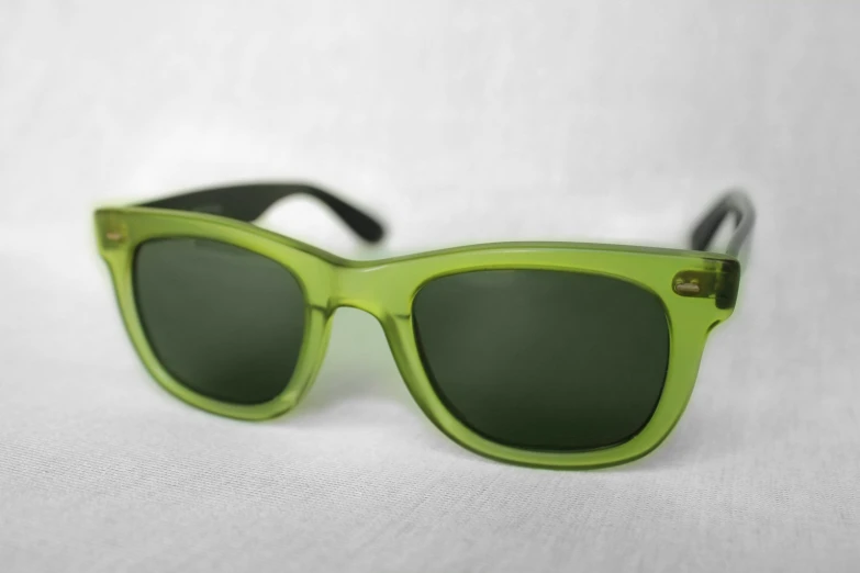 green sunglasses on white background with reflection