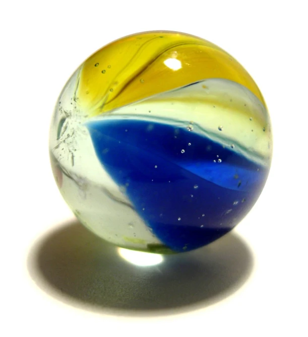 an abstract, colorful glass marble sits on a white surface