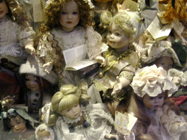 a collection of dolls are displayed in the glass case
