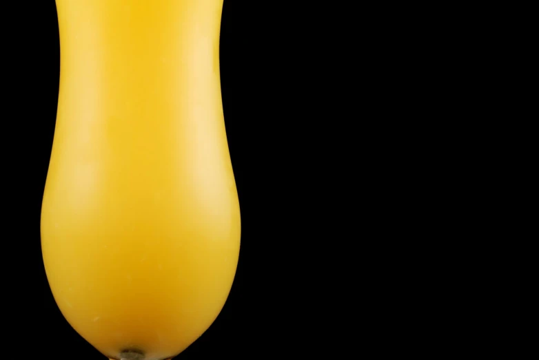 an orange colored juice is in a tall glass