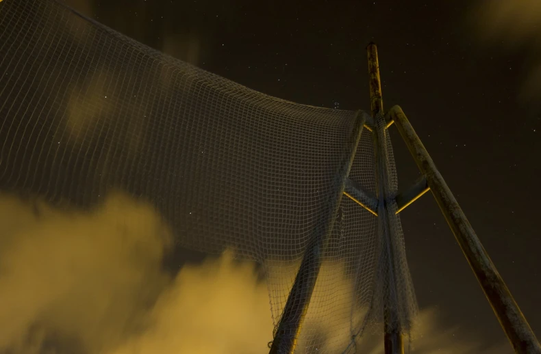 stars over a mesh fence and clouds at night