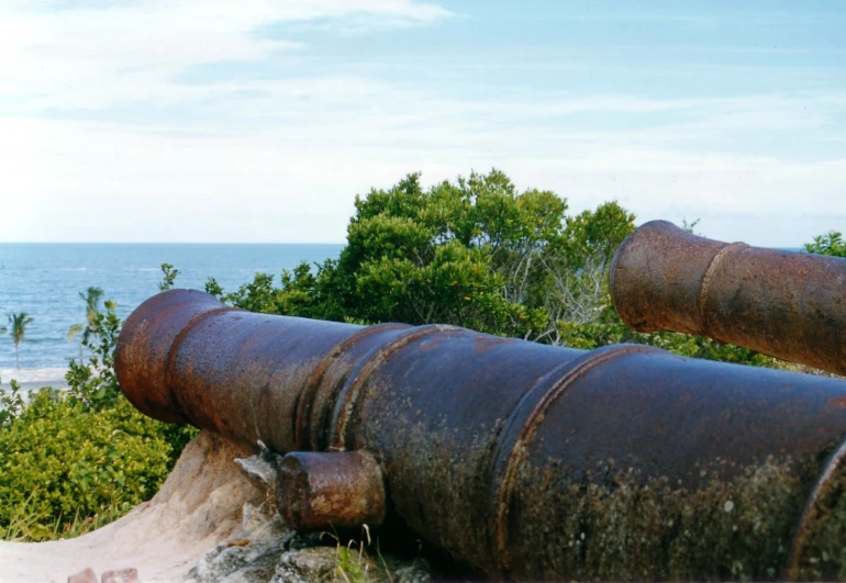 a big pipe sitting next to the ocean on a beach