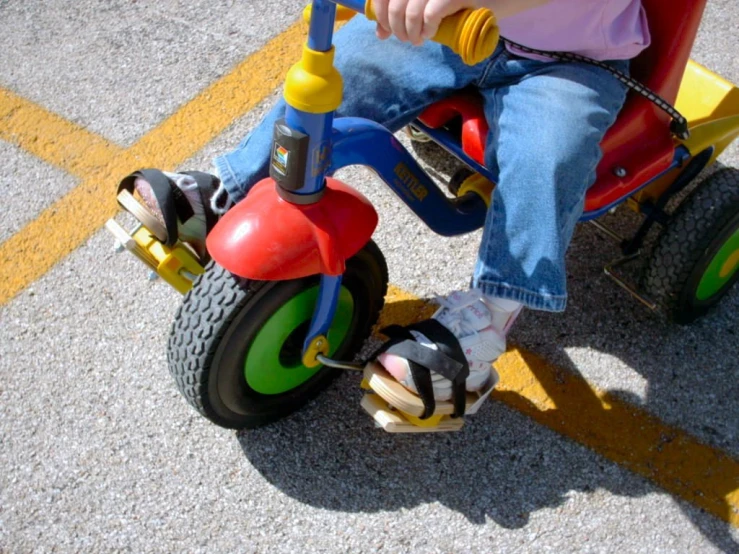 a little  riding on a colorfully colored tricycle