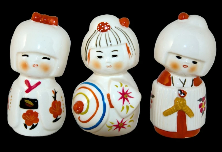 three small, decorative salt and pepper shakers with asian design