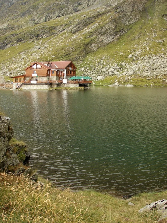 a house is sitting in a lake in the middle of a field
