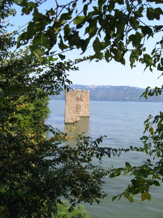a tower sits on the edge of some water