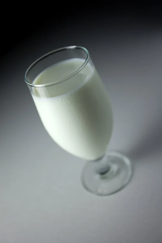 a glass of milk sitting on top of a white surface