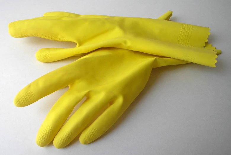 yellow gloves are folded next to each other on a table