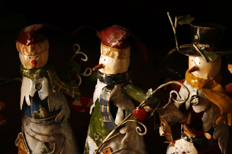 four ceramic figurines made to look like they have been dressed up