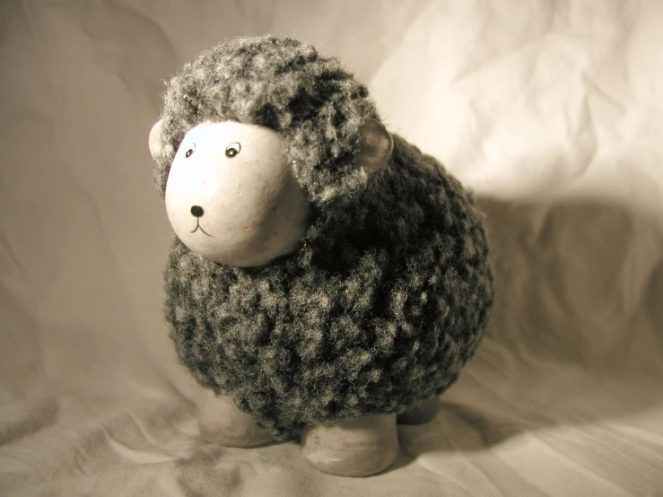 the stuffed animal sheep is made up of grey yarn