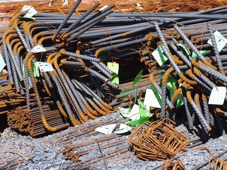 many steel bars stacked together with small white tags on them