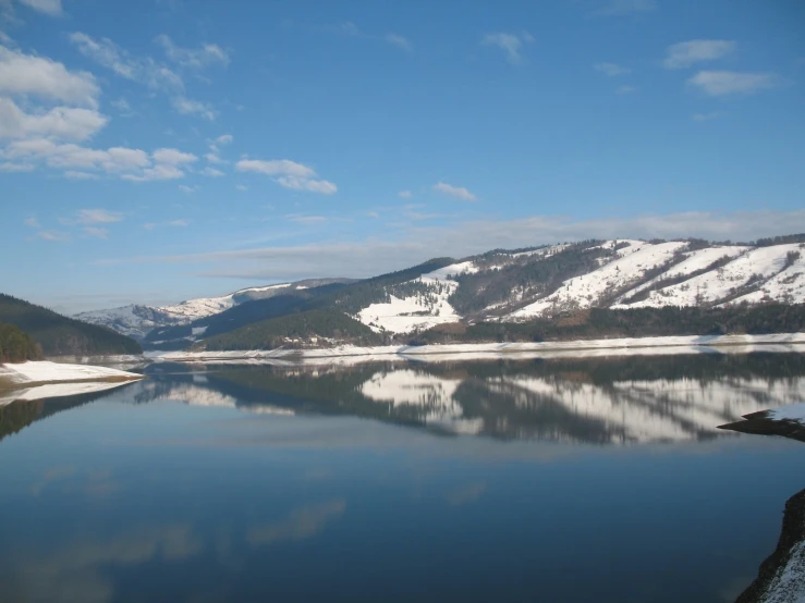 a mountain landscape that is reflected in a lake