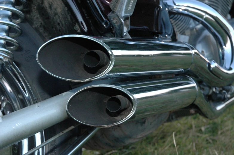 two chrome pipes are on the back of a motorcycle