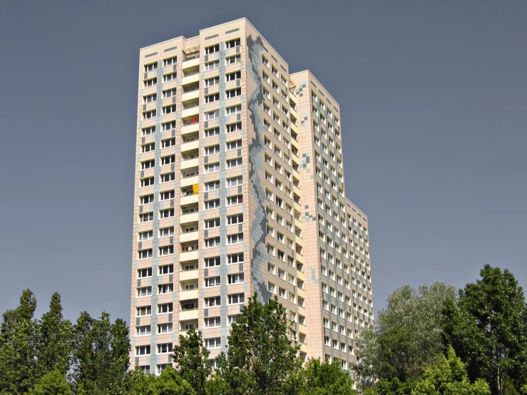 a tall building next to the trees and sky