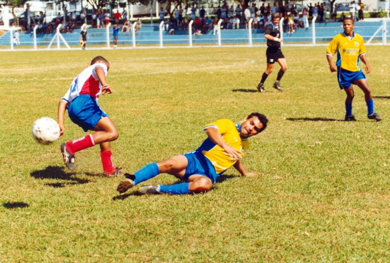two players in uniforms are trying to beat off a soccer player on the field