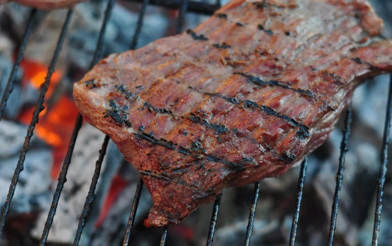 a steak is being cooked on the grill