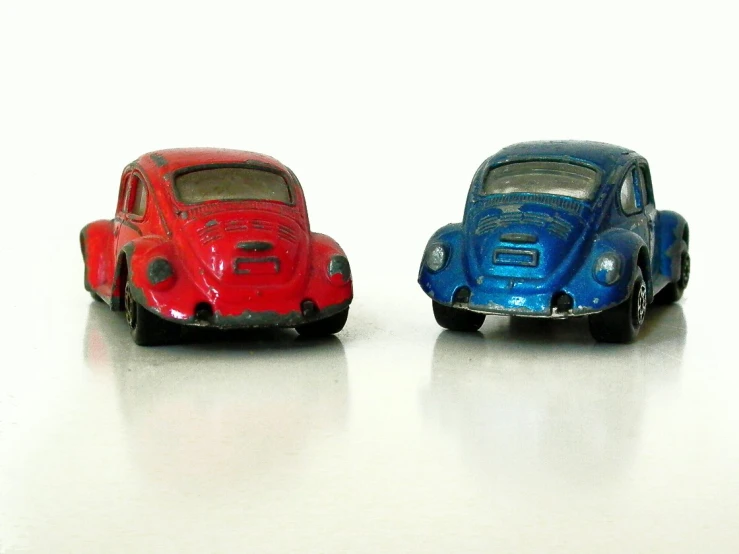 two toy cars sitting on a white table
