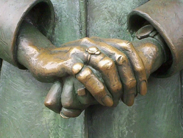 a bronze sculpture with two hands sticking out of it