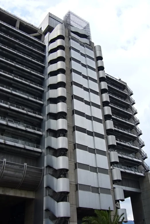 a tall building with lots of windows near a tree