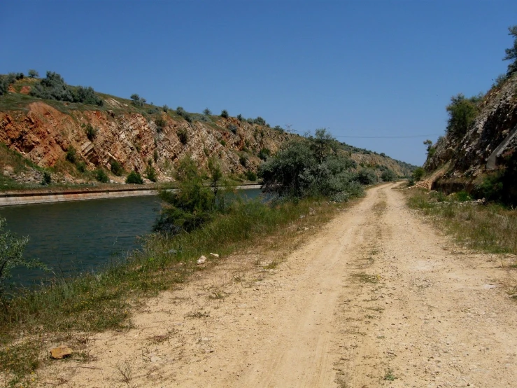 a dirt road that runs beside the water