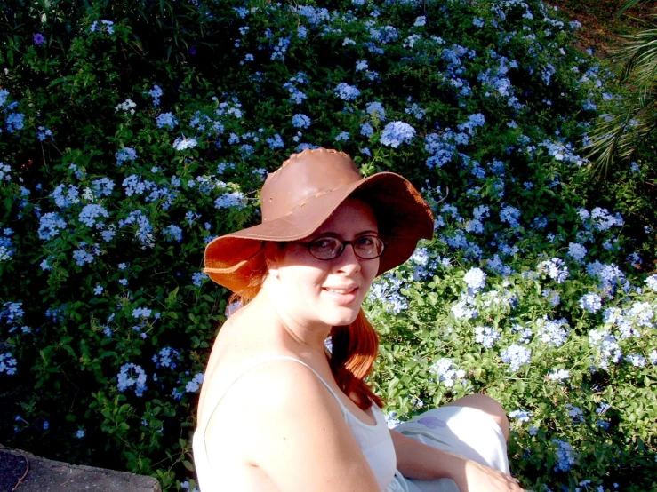 a woman wearing a hat is smiling and looking at the camera