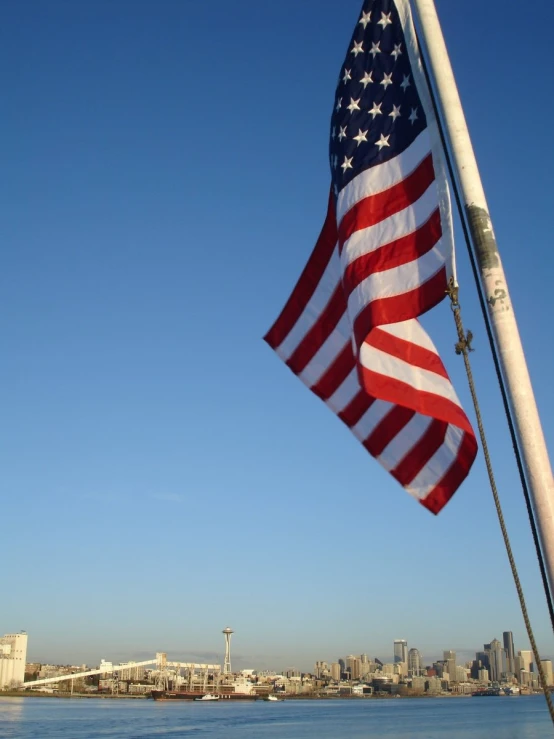 there is an american flag flying next to the water