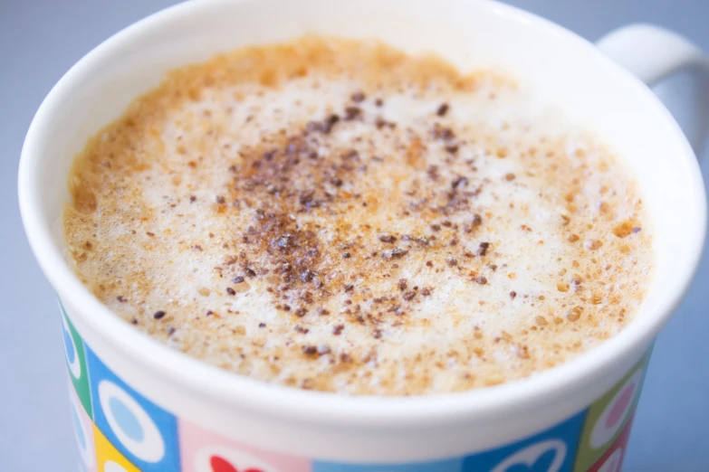 a mug filled with cinnamon on top of a blue table