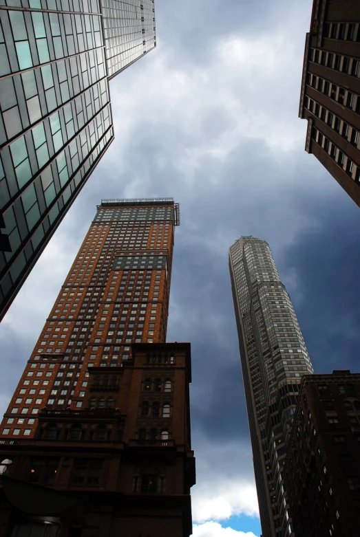 a couple of very tall buildings against the cloudy sky