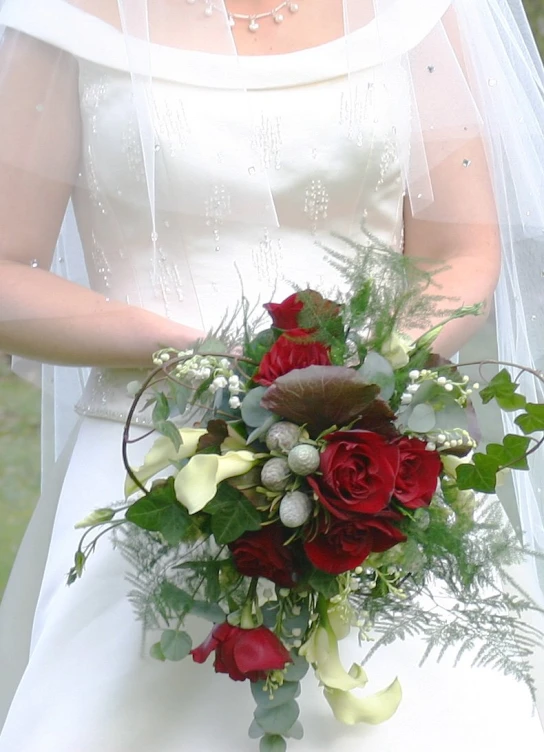 a bride holding a bouquet of flowers in front of her