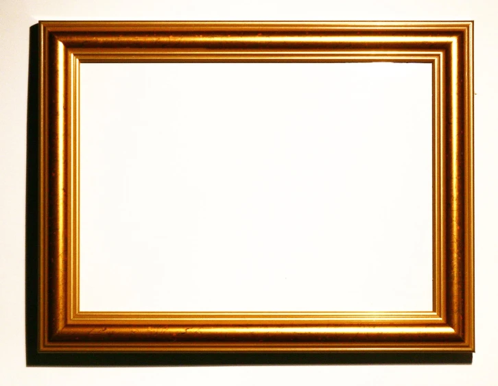 a square, golden framed pograph is placed on a white wall