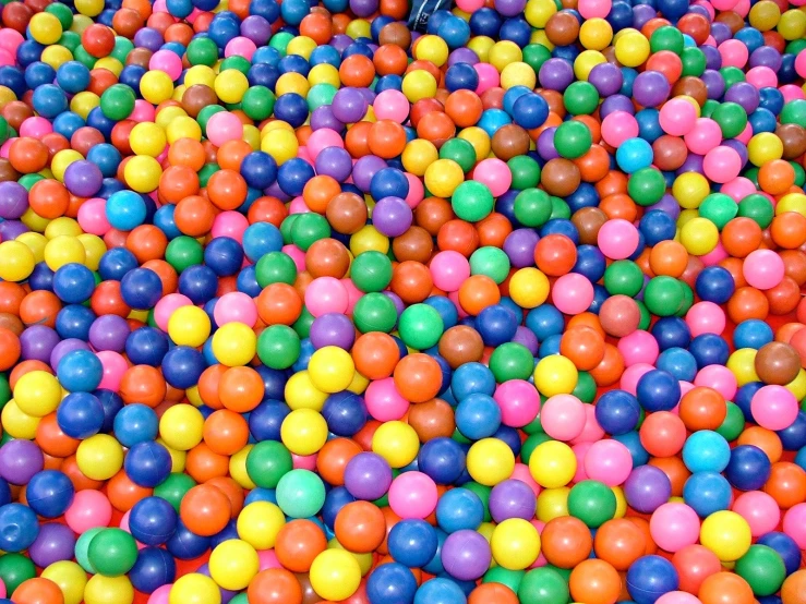 a large pile of balls is surrounded by plastic ones