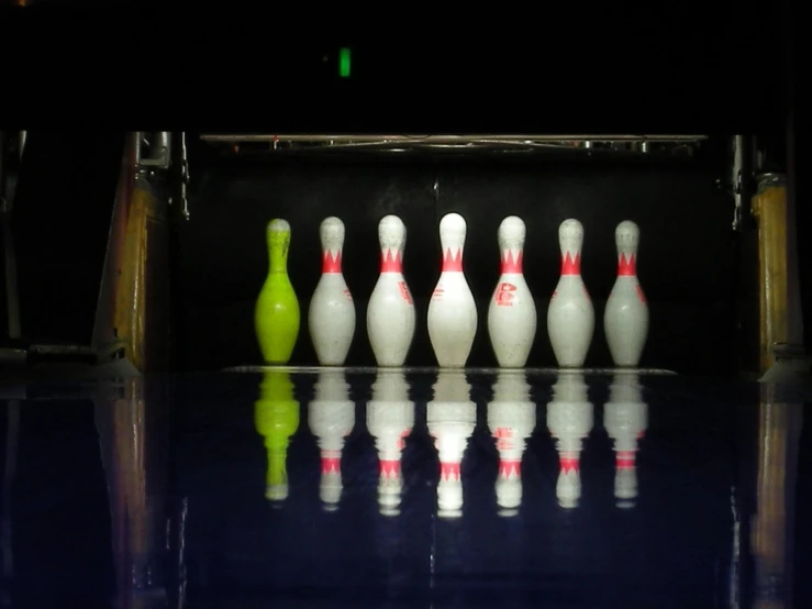 several bowling pins and a bowling ball sit in the middle of the bowling alley