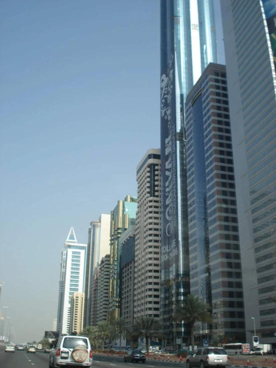 a street scene with traffic, buildings and palm trees