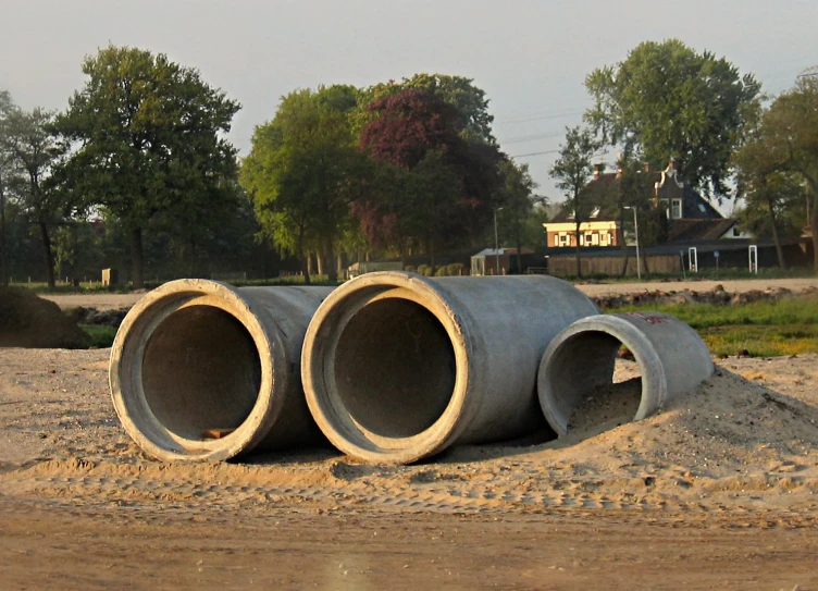 some large pipes are laying in the middle of a big field