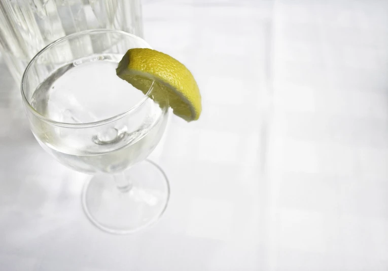 a martini glass with a lime and a straw garnished