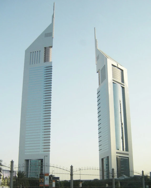 two large buildings sitting behind a fence