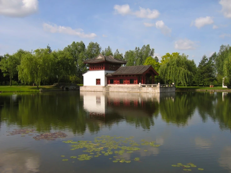 a lake and pavilion with lily padding next to it