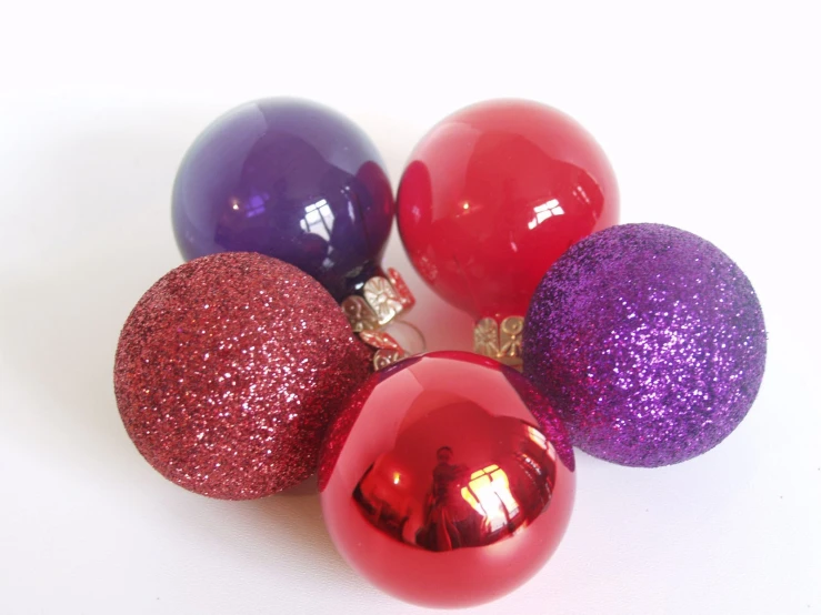 three ornaments in the shape of balls are lined up on a table