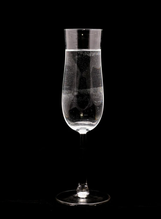a wine glass with some water sitting on a table