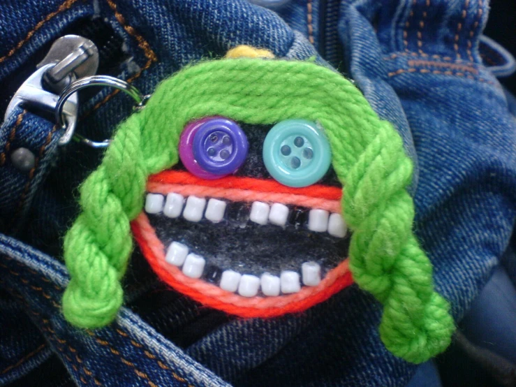 there is a knitted face with two colorful ons attached to it