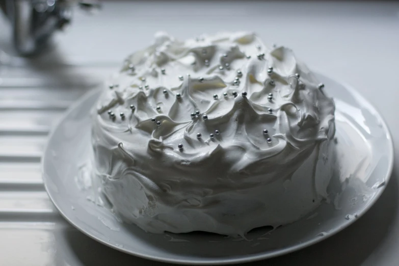 there is a cake with white icing on a plate