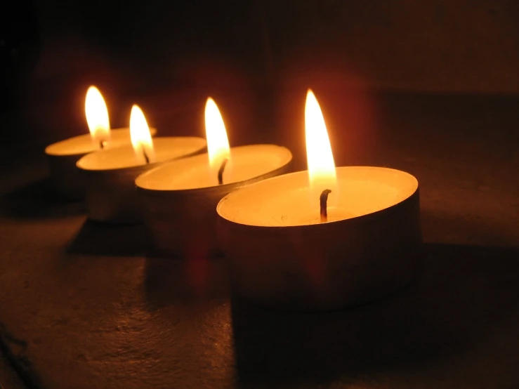 five small candles sitting in the dark with bright light